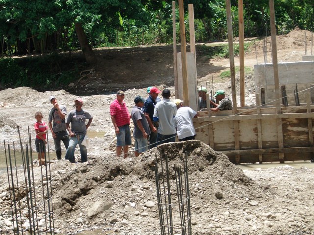 Con ayuda mutua comunitarios construyen puente de La Piragua en Imbert